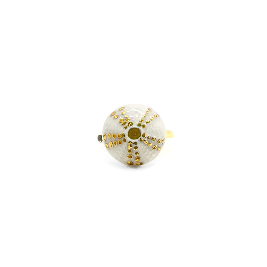 Anillo de azulejos blancos con líneas doradas.